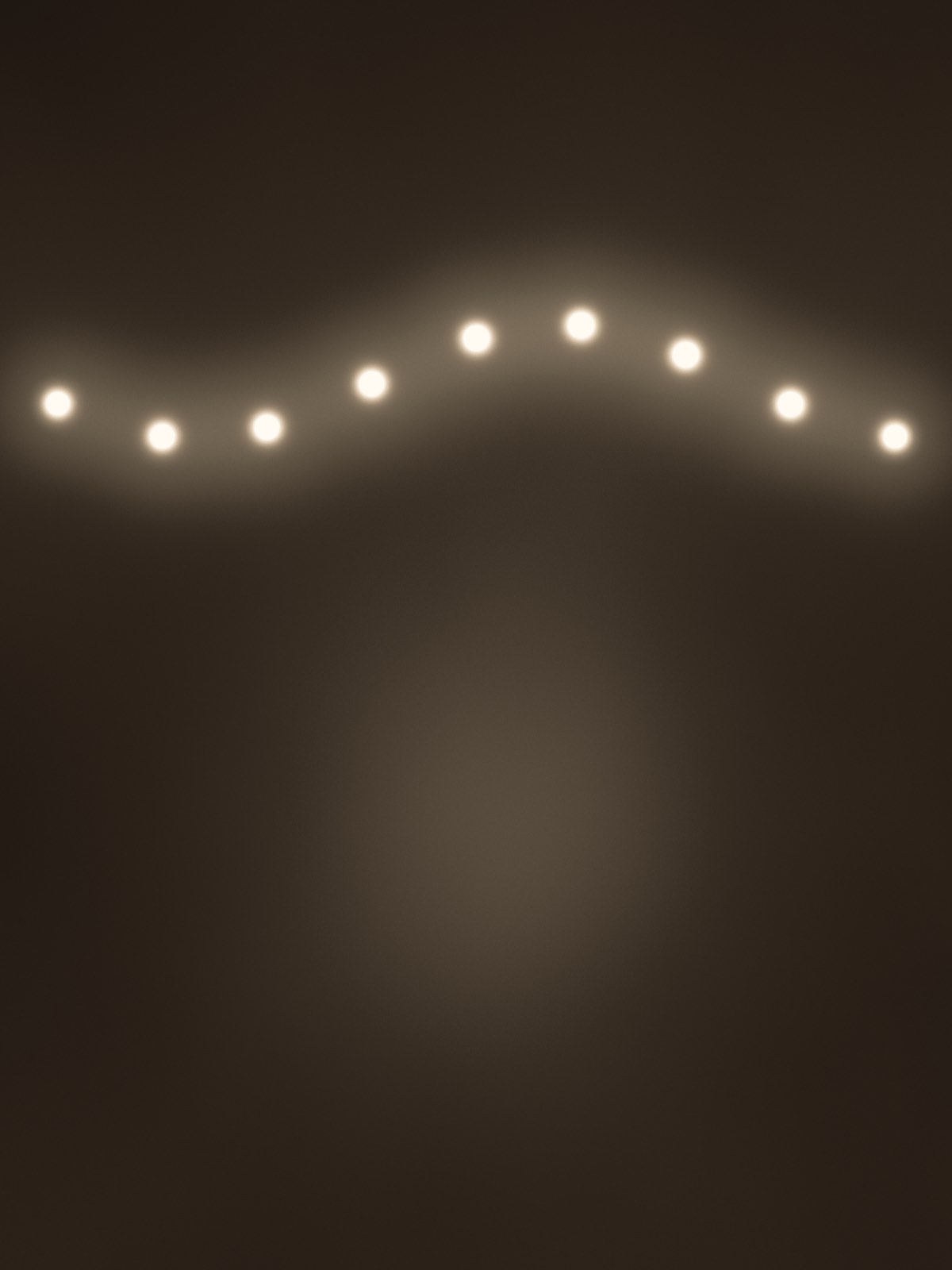 A drawn placeholder plate: a single strand of bulbs slung across a near-dark room, the floor beneath it barely reading.